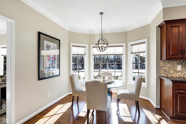 dining area featuring ornamental molding, dark hardwood / wood-style flooring, and a chandelier