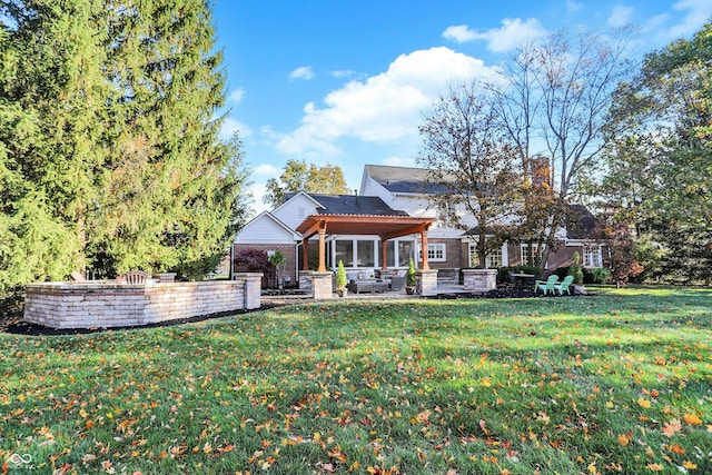 back of property with a yard and a patio area