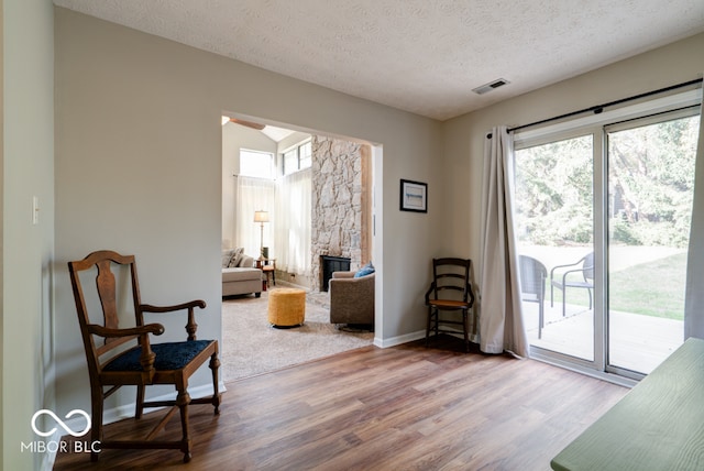 sitting room with a textured ceiling and wood-type flooring