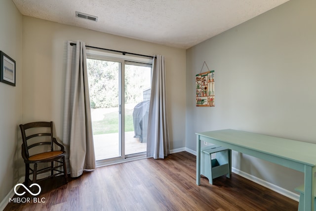 doorway to outside with a textured ceiling and dark hardwood / wood-style floors