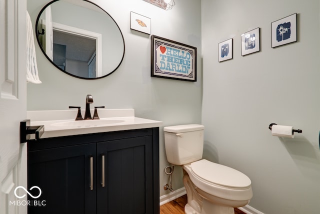 bathroom featuring toilet, hardwood / wood-style floors, and vanity