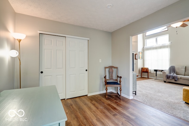 interior space with ceiling fan, a textured ceiling, and hardwood / wood-style floors