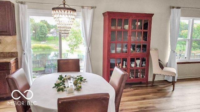 dining space with hardwood / wood-style flooring and a chandelier