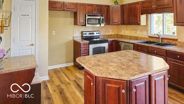 kitchen featuring sink, a center island, stainless steel appliances, and tasteful backsplash