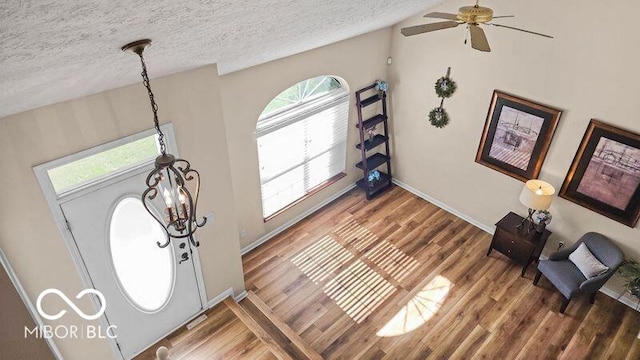 entryway featuring wood-type flooring, ceiling fan, a textured ceiling, and lofted ceiling