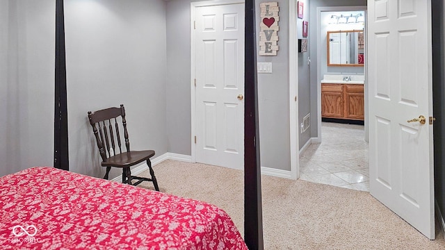 carpeted bedroom featuring sink and ensuite bathroom