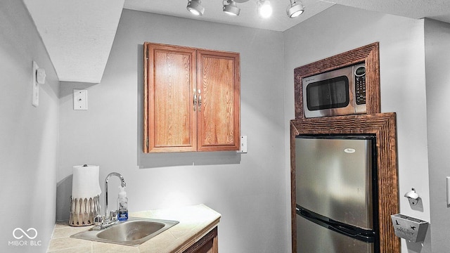 kitchen with sink, stainless steel appliances, and tile counters