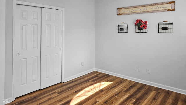 unfurnished bedroom with a closet and dark wood-type flooring