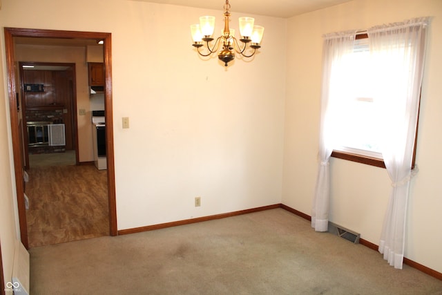 unfurnished room featuring a notable chandelier and light colored carpet