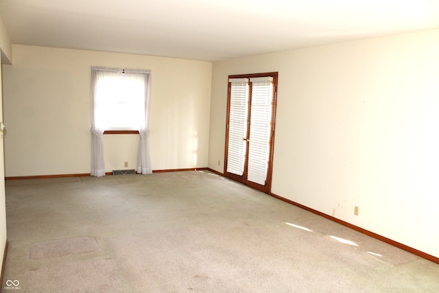 spare room featuring light colored carpet