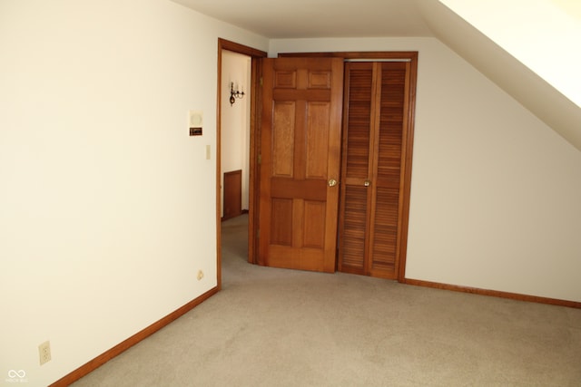 bonus room featuring lofted ceiling and light colored carpet