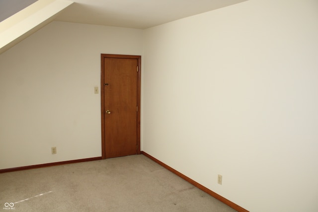 unfurnished room with light carpet and lofted ceiling with skylight