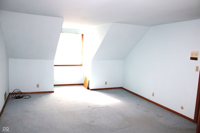 additional living space with lofted ceiling and light colored carpet