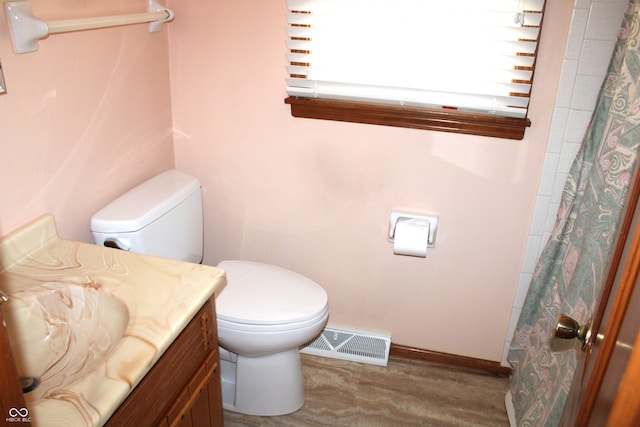 bathroom featuring vanity, toilet, wood-type flooring, and walk in shower