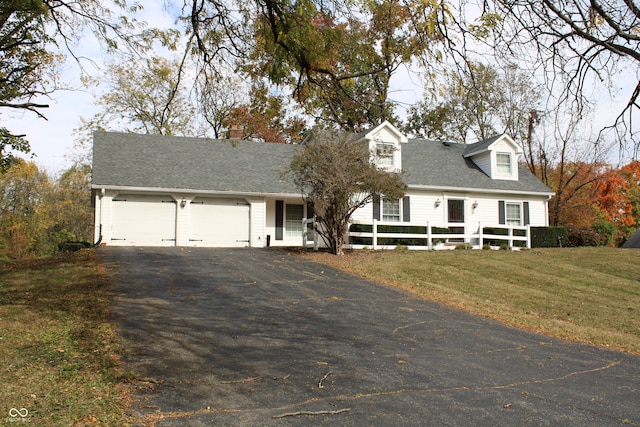 cape cod-style house featuring a front lawn and a garage