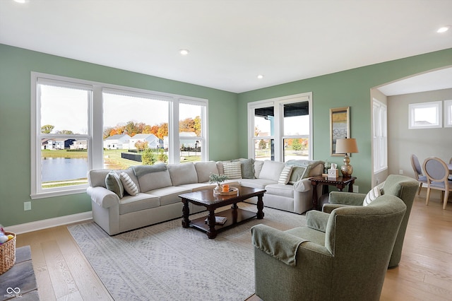 living room featuring light hardwood / wood-style floors and a water view