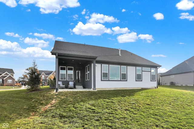 back of property with cooling unit, a yard, and a patio area