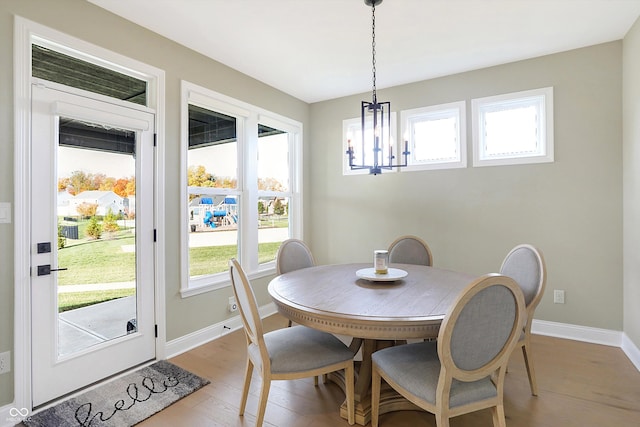 dining area with light hardwood / wood-style floors and a chandelier