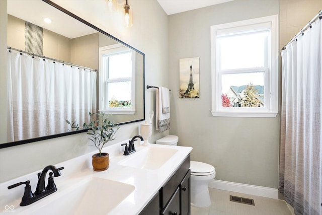 bathroom featuring tile patterned flooring, vanity, and toilet