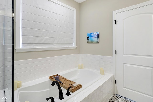 bathroom with tile patterned floors and tiled tub