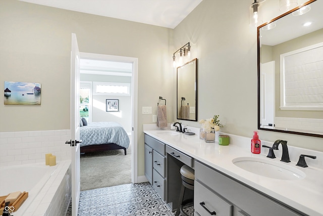 bathroom with tiled bath, tile patterned flooring, and vanity