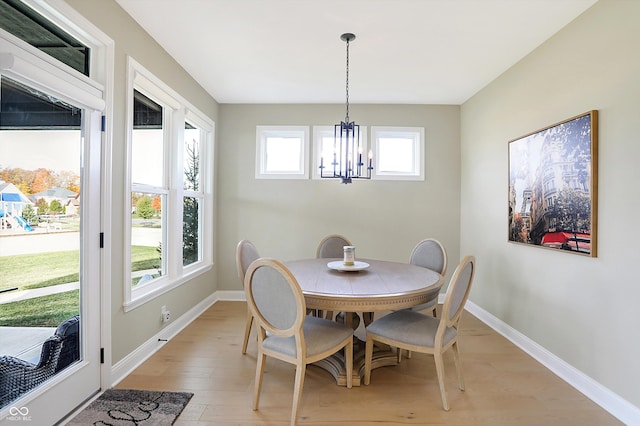 dining space featuring light hardwood / wood-style flooring, an inviting chandelier, and plenty of natural light