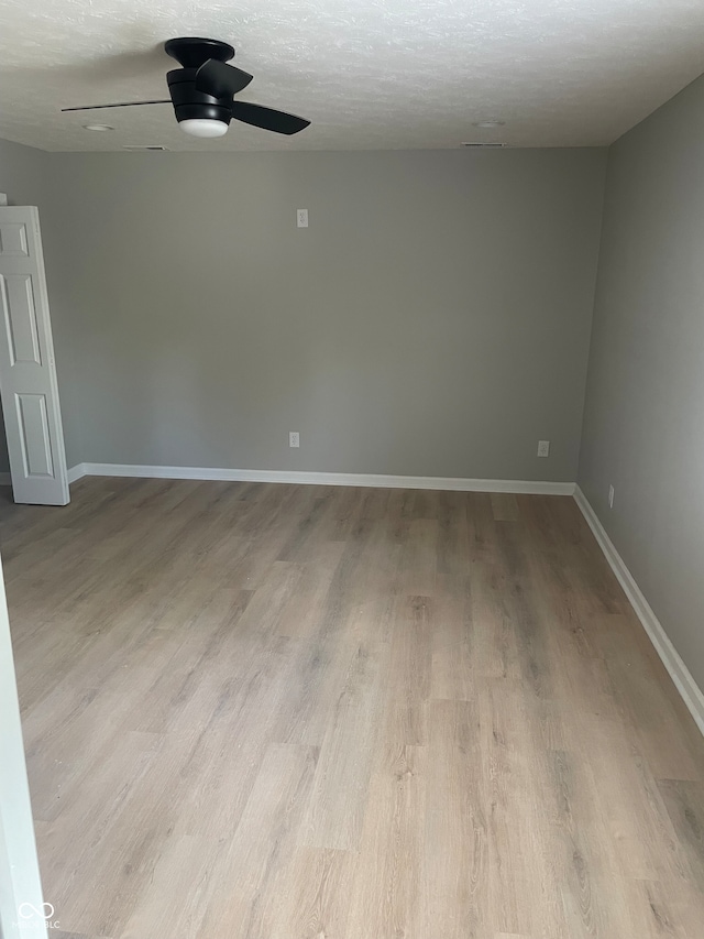 unfurnished room featuring ceiling fan, a textured ceiling, and light wood-type flooring