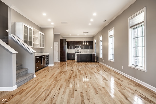 unfurnished living room featuring ornamental molding and light hardwood / wood-style flooring