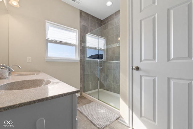 bathroom featuring vanity, walk in shower, and tile patterned flooring