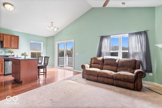 living room featuring hardwood / wood-style flooring, a chandelier, and high vaulted ceiling