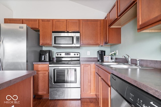 kitchen with stainless steel appliances, dark wood-type flooring, sink, and vaulted ceiling