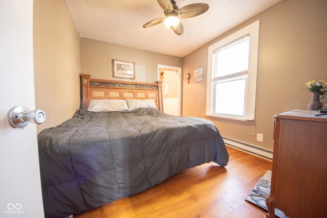 bedroom featuring light wood-type flooring, ceiling fan, and baseboard heating