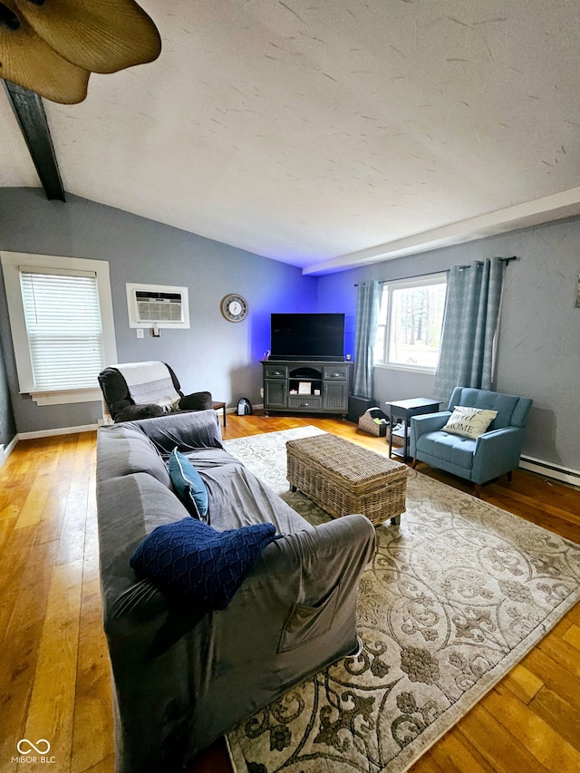 living room featuring wood-type flooring, lofted ceiling with beams, and a wall unit AC