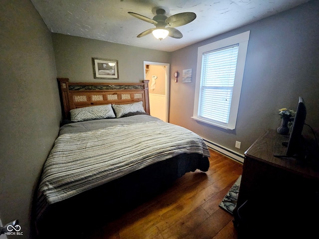 bedroom featuring a baseboard heating unit, ceiling fan, and dark hardwood / wood-style flooring