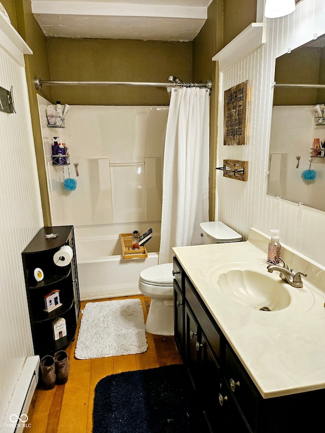 full bathroom featuring hardwood / wood-style floors, vanity, a baseboard heating unit, shower / tub combo, and toilet