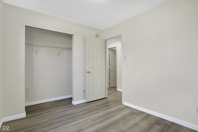 unfurnished bedroom featuring a closet and wood-type flooring