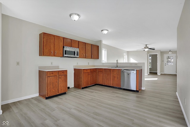 kitchen with sink, light hardwood / wood-style flooring, stainless steel appliances, and ceiling fan