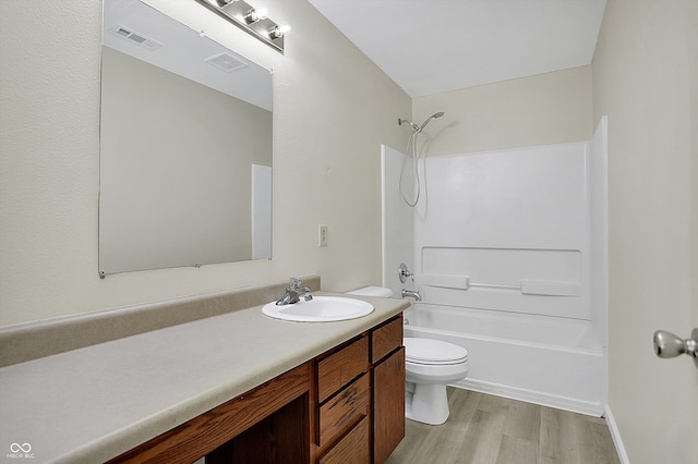 full bathroom featuring toilet, bathtub / shower combination, hardwood / wood-style floors, and vanity