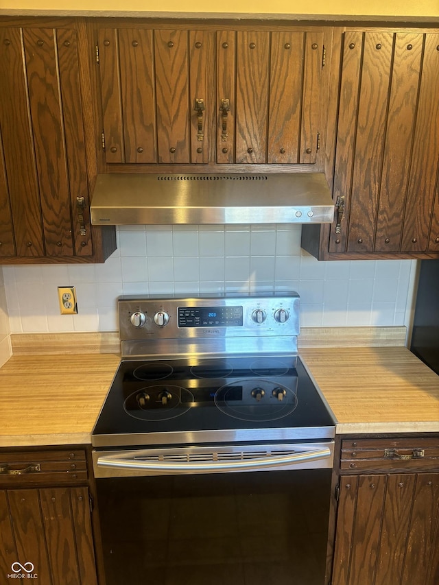 kitchen featuring backsplash, stainless steel electric range oven, and range hood