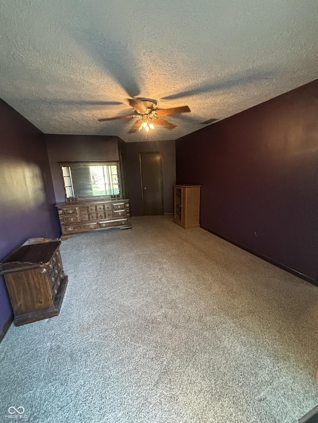 unfurnished living room featuring carpet flooring, a textured ceiling, and ceiling fan