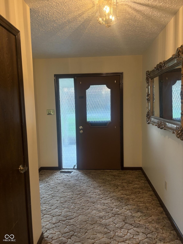 doorway featuring a textured ceiling and carpet floors