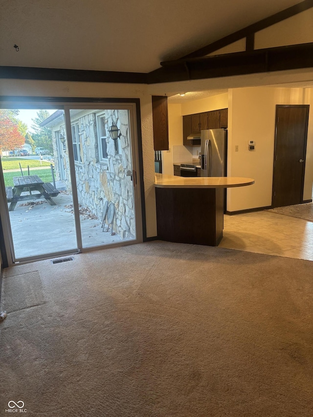 unfurnished living room featuring light carpet and vaulted ceiling