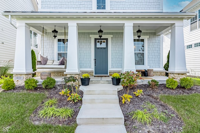 view of exterior entry featuring covered porch