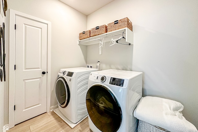 washroom featuring washer and dryer and light hardwood / wood-style floors