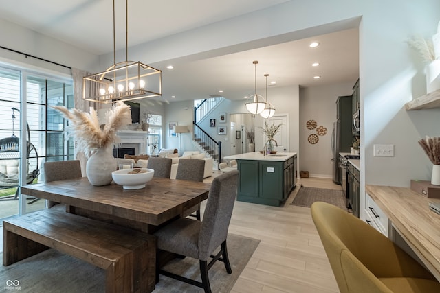 dining room with a chandelier, sink, and light hardwood / wood-style floors