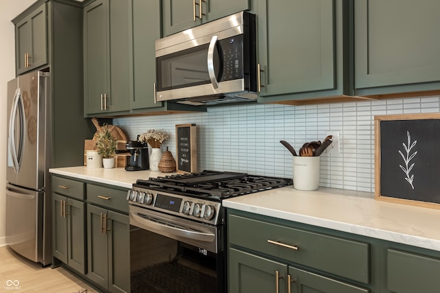 kitchen with appliances with stainless steel finishes and green cabinetry