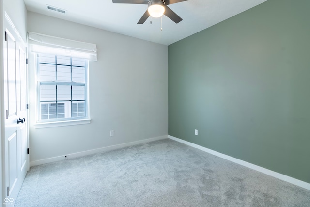 carpeted spare room with ceiling fan