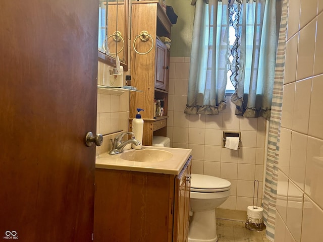 3305 N Keystone Ave, Indianapolis, IN 46218 - bathroom featuring tile walls, vanity, healthy amount of natural light, tile patterned floors, and a shower