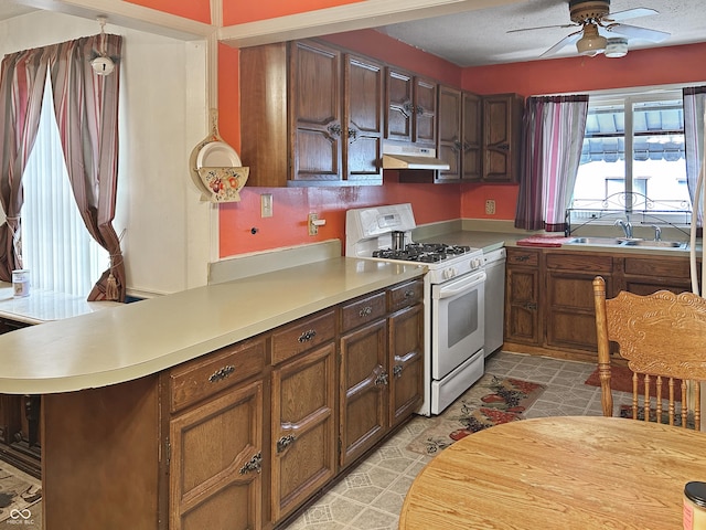 3305 N Keystone Ave, Indianapolis, IN 46218 - kitchen with gas range gas stove, under cabinet range hood, ceiling fan, and light countertops