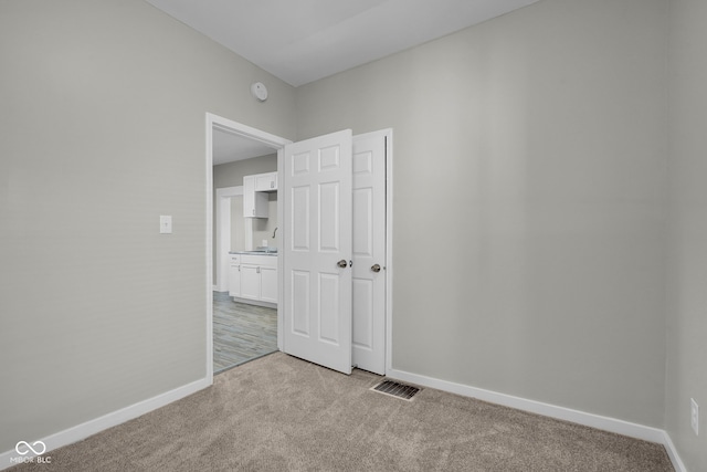 spare room featuring light colored carpet